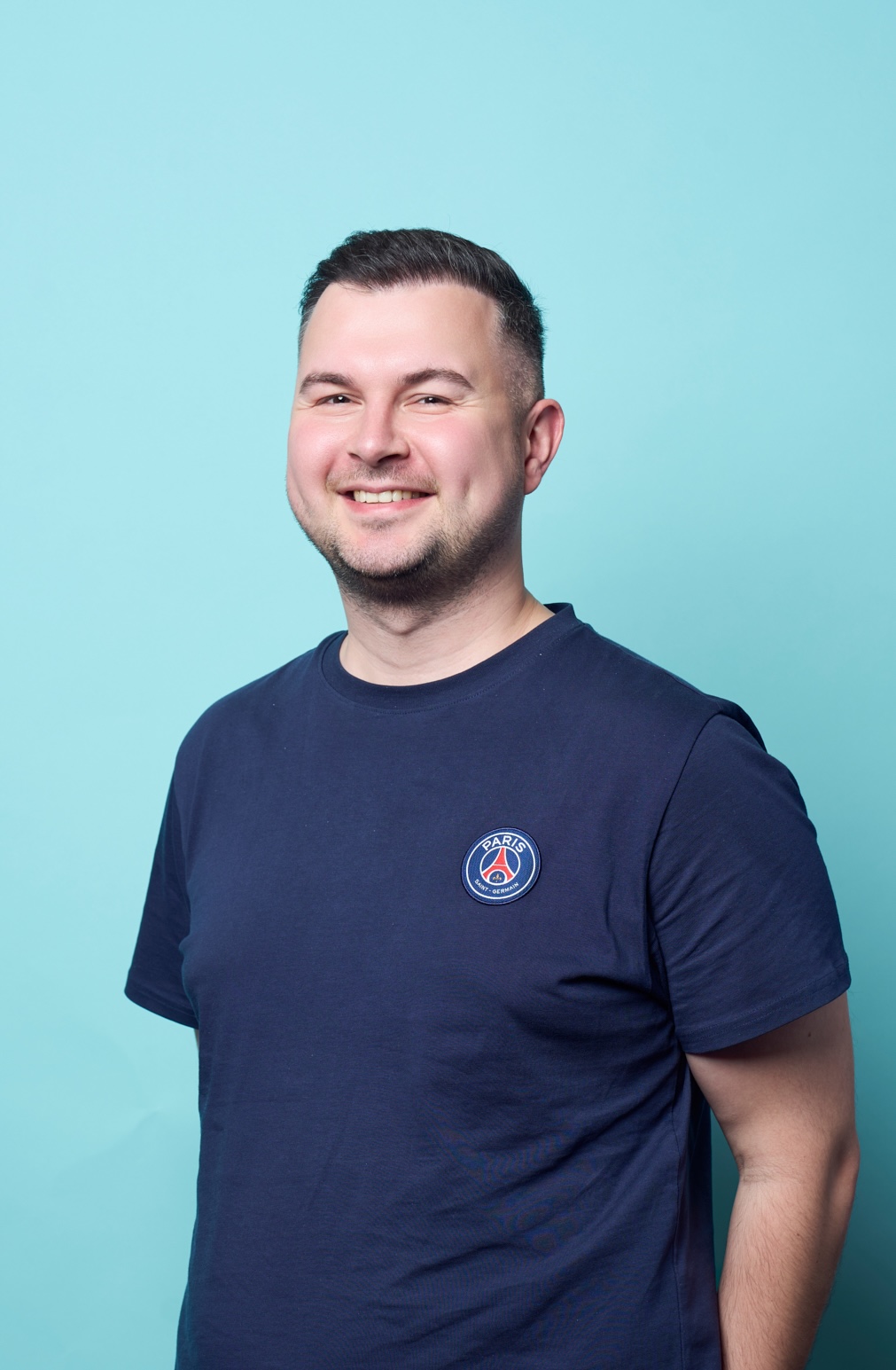 Portrait, freundlich lächelnd vor türkisem Hintergrund